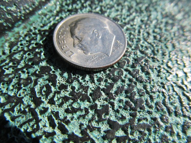 1.6.3 Detailed photograph of surface pitting on historic  bronze sculpture.
